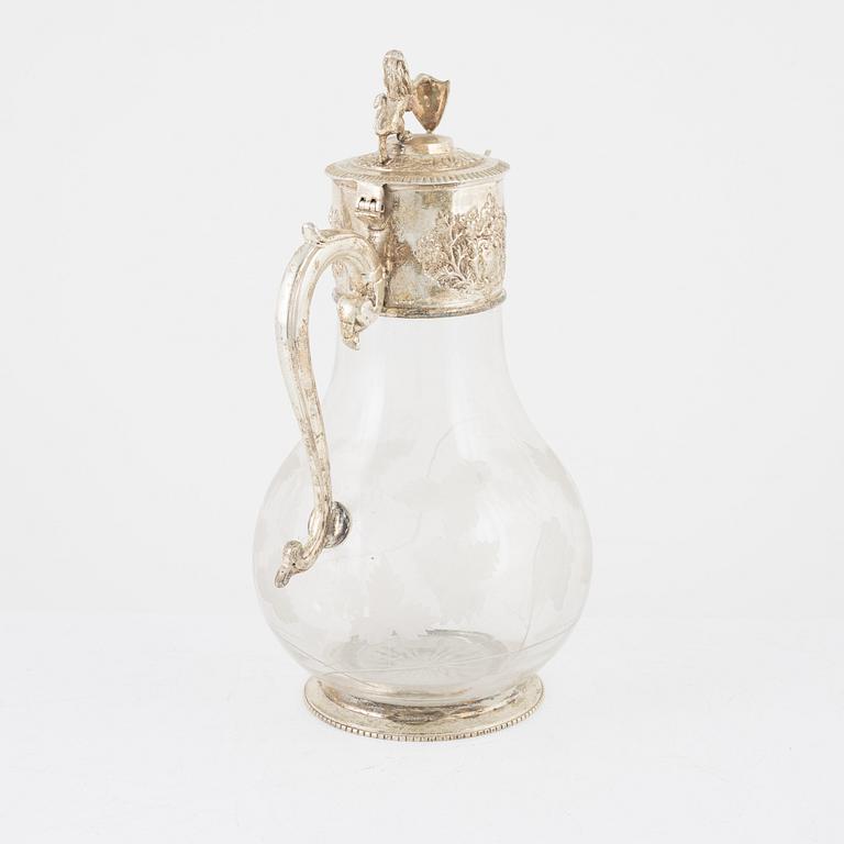 A glass and silver plated jug, around the year 1900.