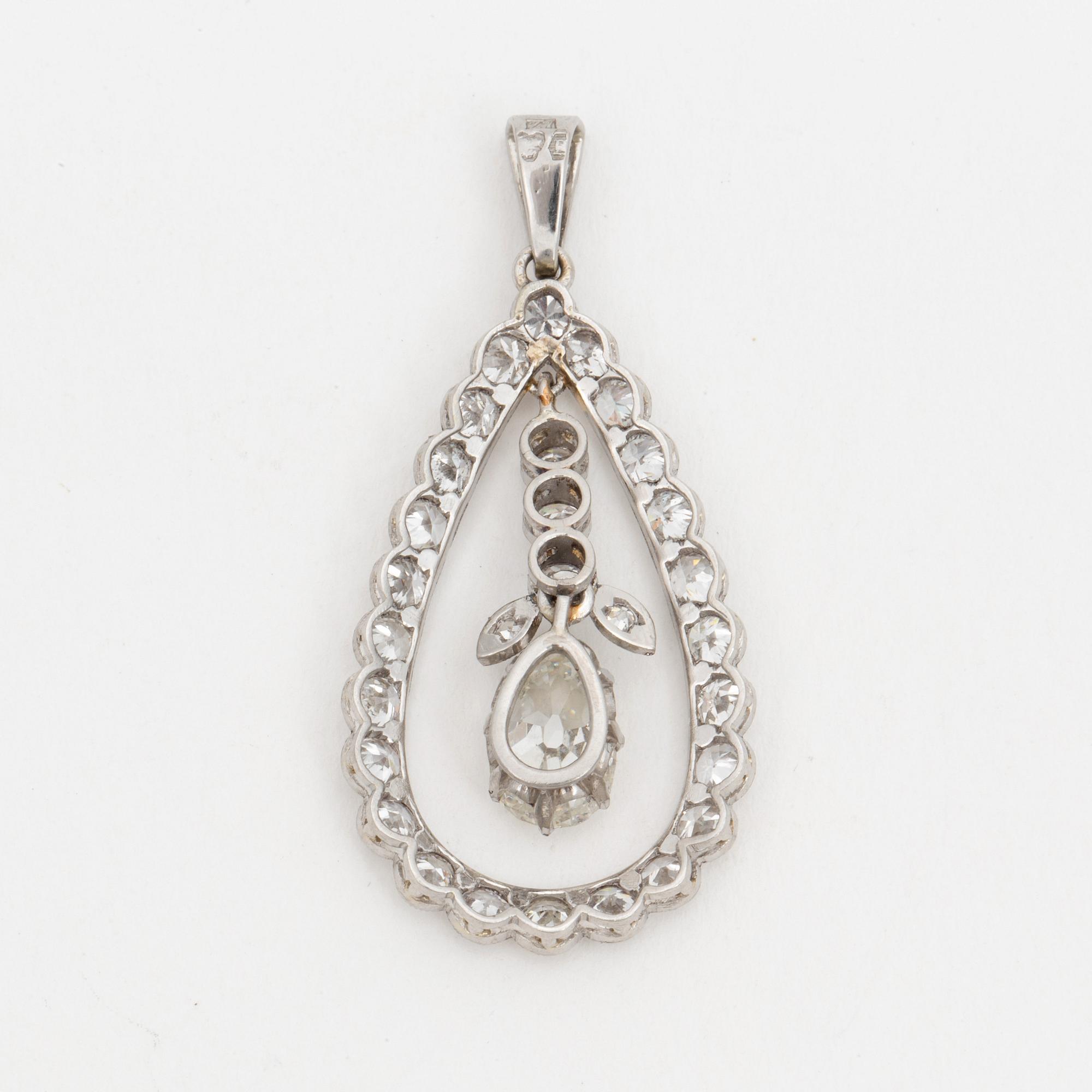 A pendant set with a pear cut diamond surrounded by old cut diamonds.