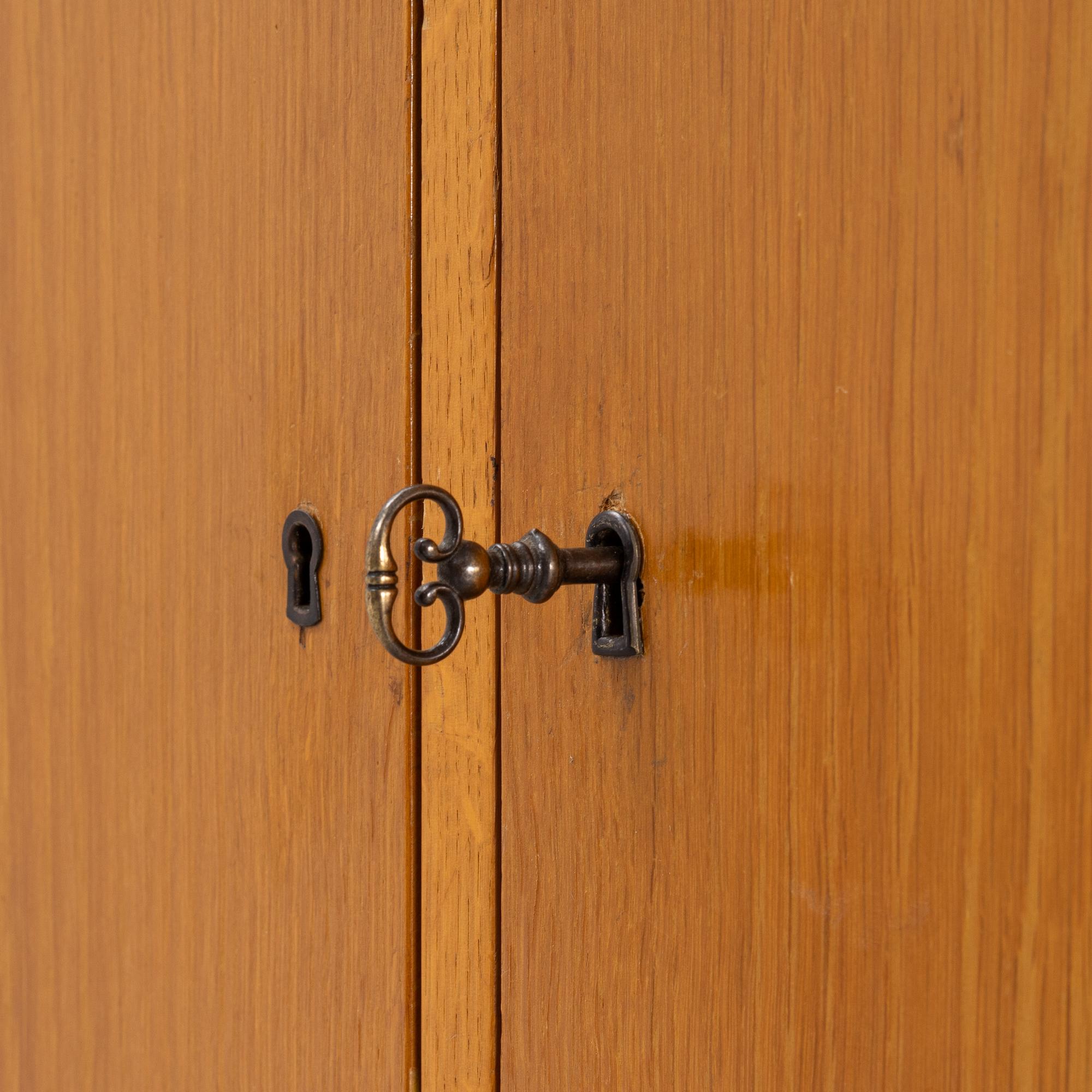 An oak veneered cabinet. 20th Century.