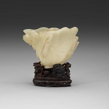 19. A nephrite brush washer, on a hardwood stand with silver inlay, Qing dynasty (1644-1912).