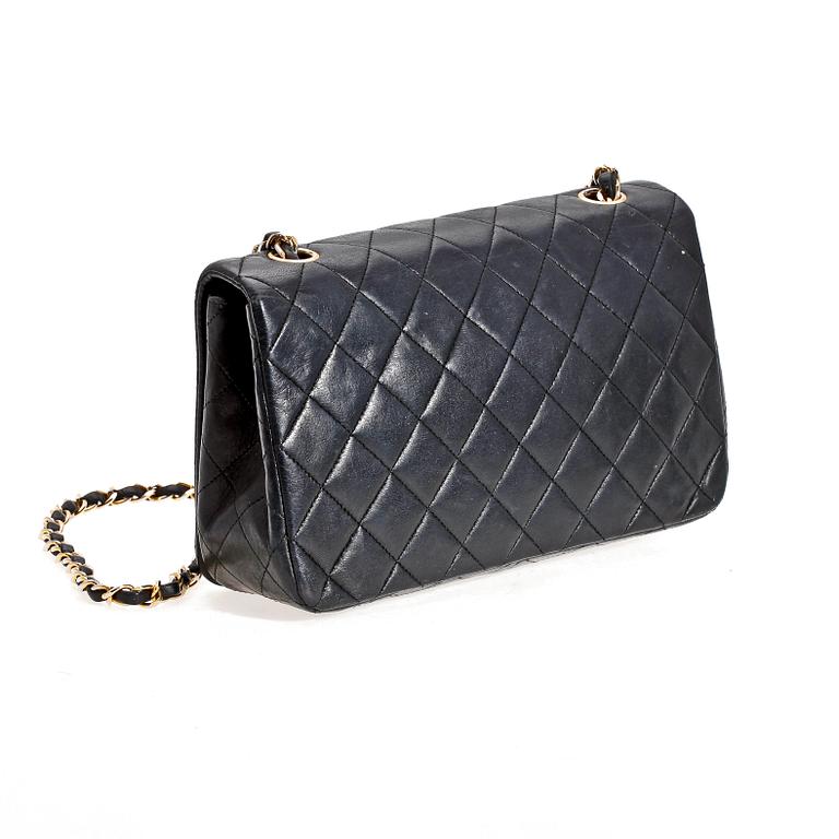 A black quilt leather shoulder bag by Chanel.