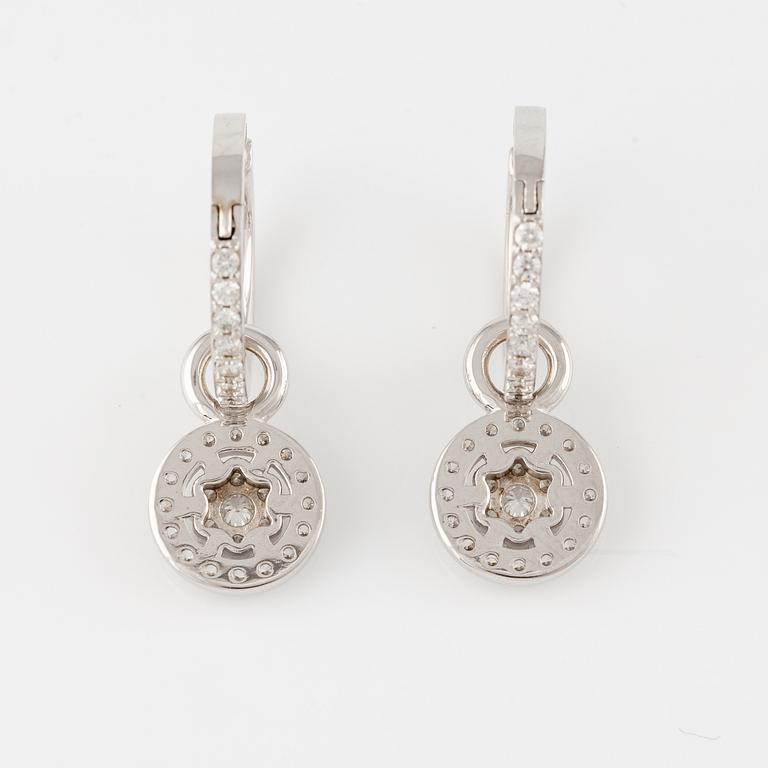 A pair of 18K gold earrings with round brilliant-cut diamonds.
