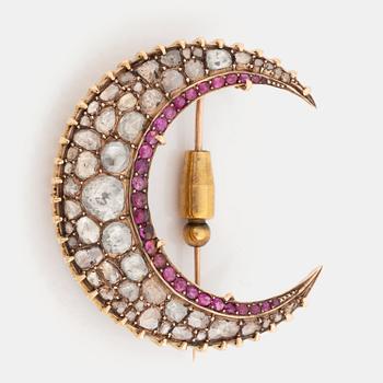 A Victorian gold crescent brooch set with rose-cut diamonds and faceted rubies.