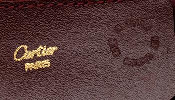 A bordeaux coloured leather weekendbag by Cartier.