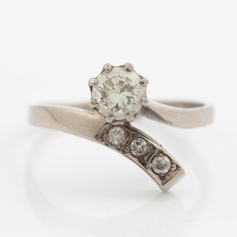 Ring, 18K vitguld med en briljantslipad diamant och  tre mindre briljantslipade diamanter.