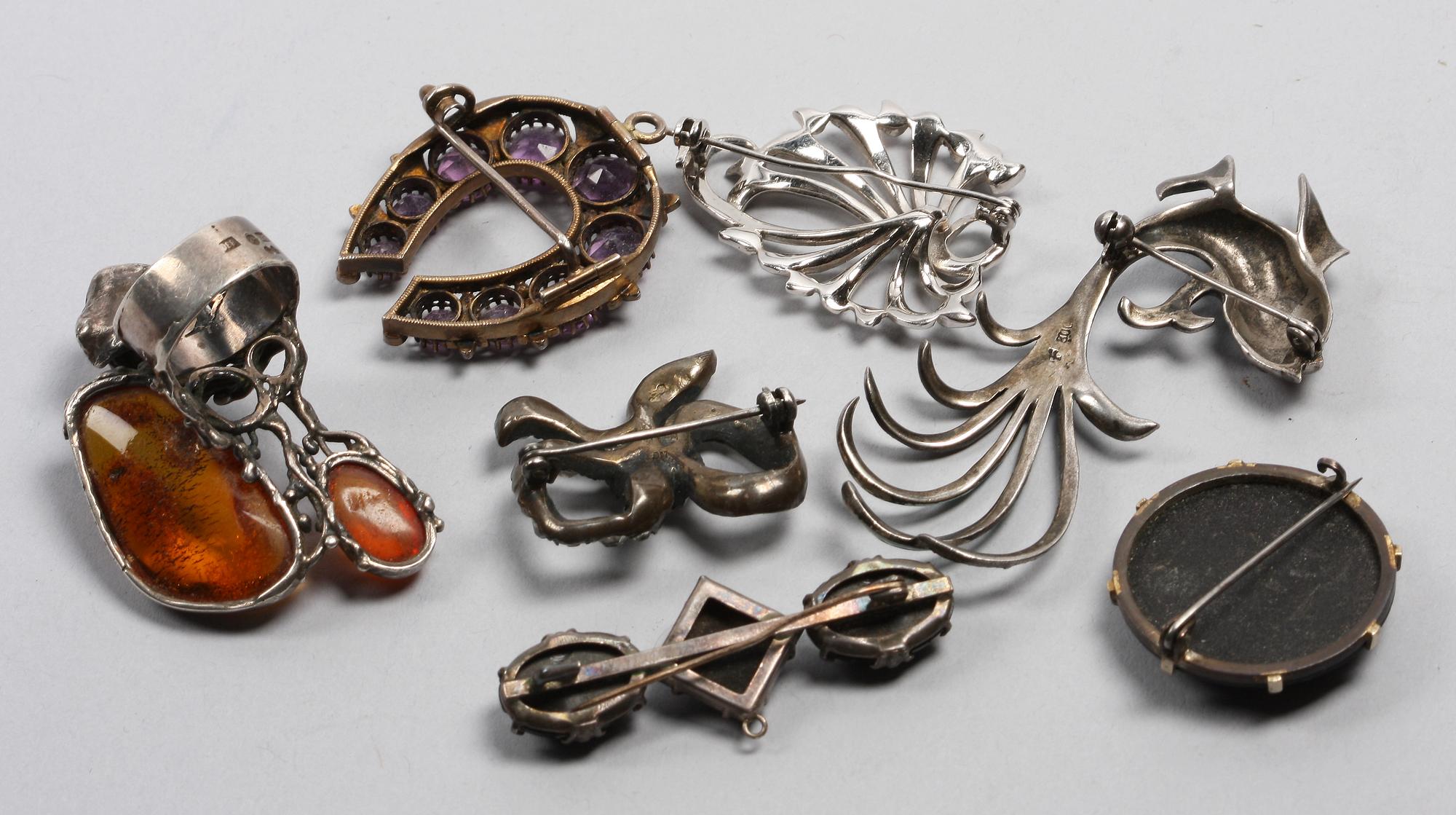 BROSCHER SAMT RING, 7 st, silver, bärnsten, emalj, markasiter. Tidigt 1900-tal/1900-talets första hälft.