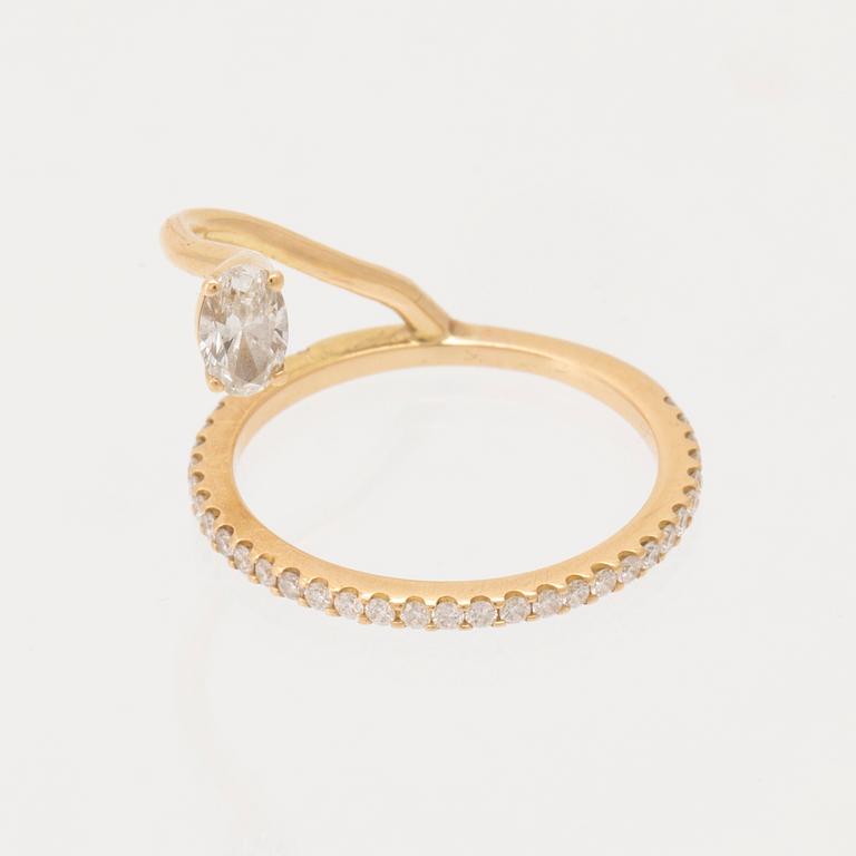 An 18K gold ring set with an oval cut and round brilliant cut diamonds by LWL Jewelry.