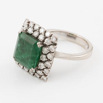 Ring in 18K white gold set with a faceted emerald and round brilliant-cut diamonds.