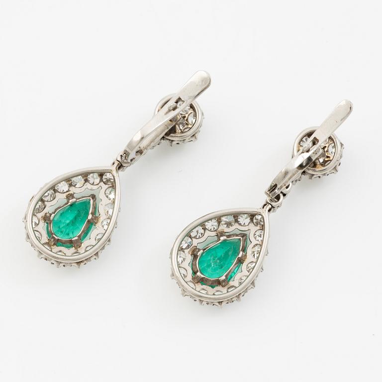 Earrings in platinum with drop-shaped emeralds and brilliant-cut and octagonal-cut diamonds.