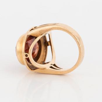 A ring with a faceted brown stone.