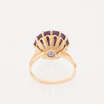 An 18K gold ring set with a round faceted colour-changing synthetic purple sapphire, Heribert Engelbert Stockholm.