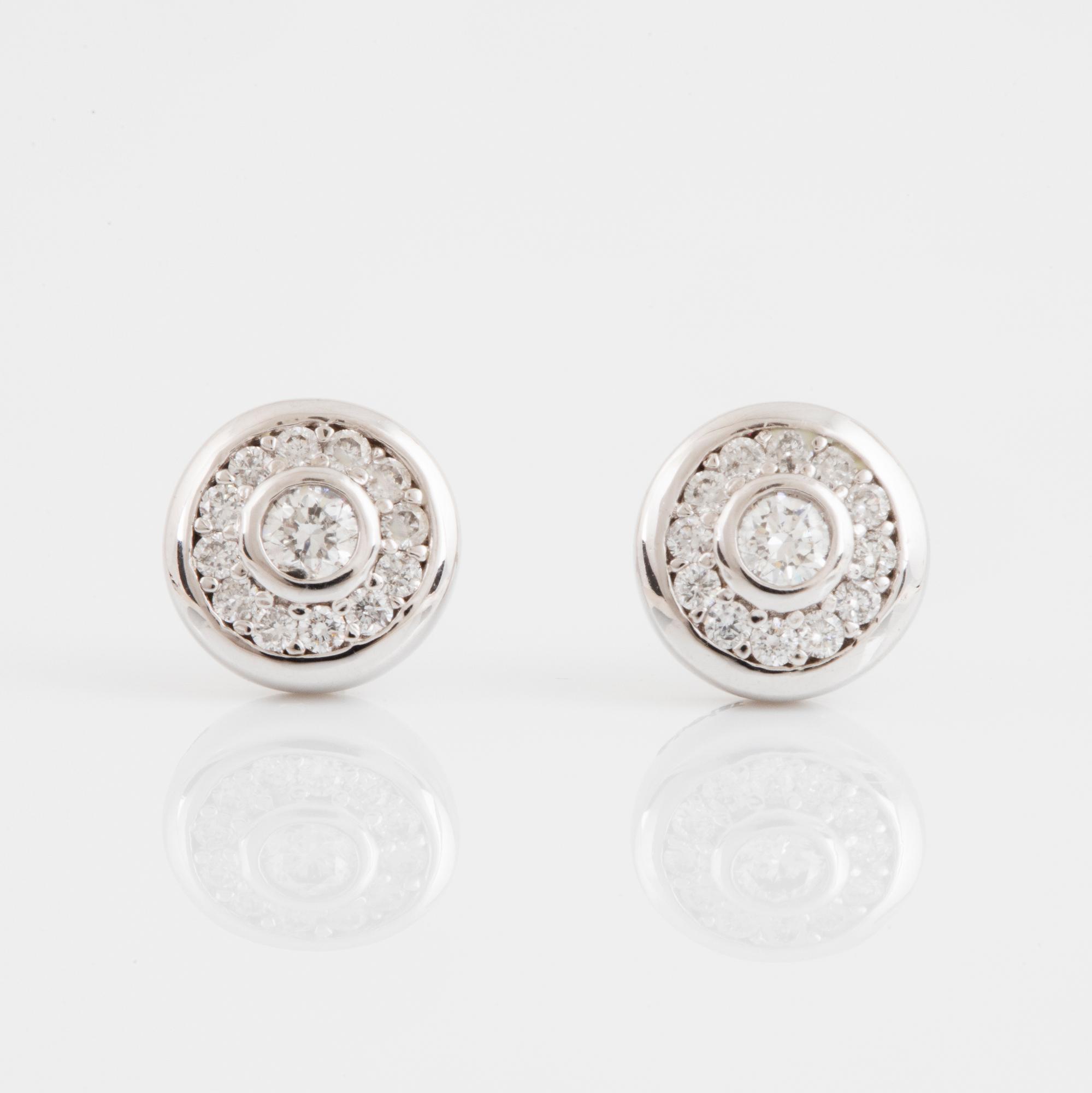 A pair of 14K gold earrings set with round brilliant-cut diamonds.