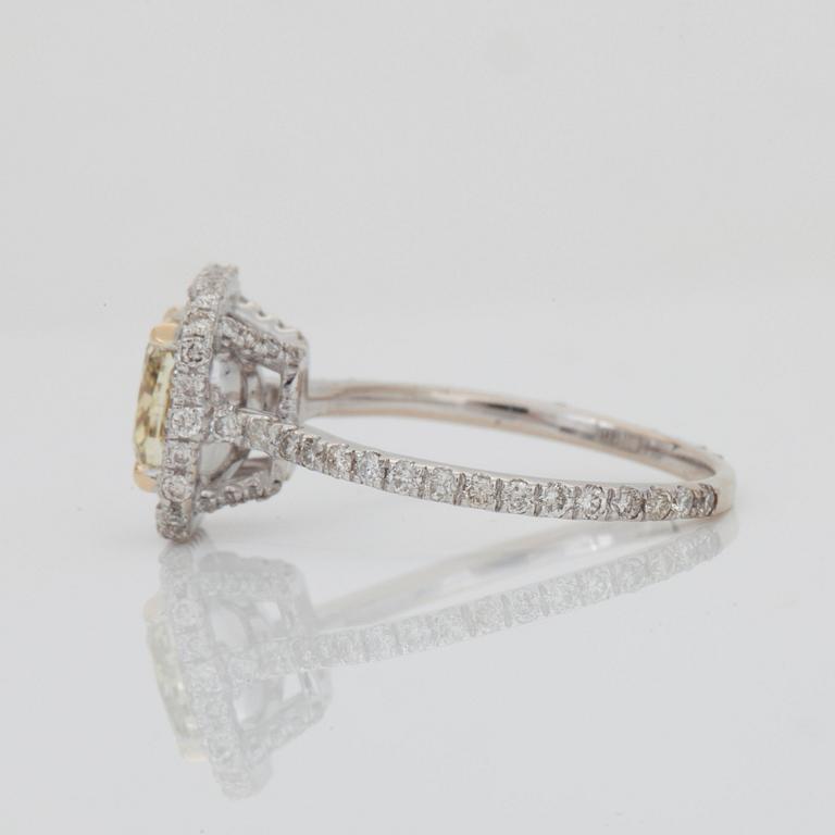 A cushion-cut fancy yellow/SI2 diamond ring. Pavé-set colourless brilliant-cut diamonds.