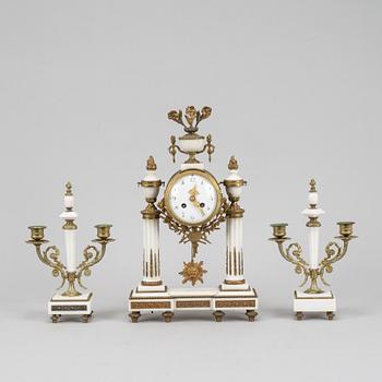 A Louis XVI style pendulum clock and a pair of candelabra, early 20th century.