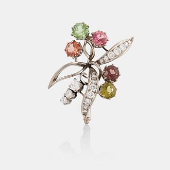 974. An 18K white gold brooch set with round- and eight-cut diamonds and coloured stones.