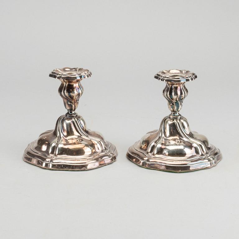 A PAIR OF SILVER ROCOCO STYLE CANDLE STICKS.