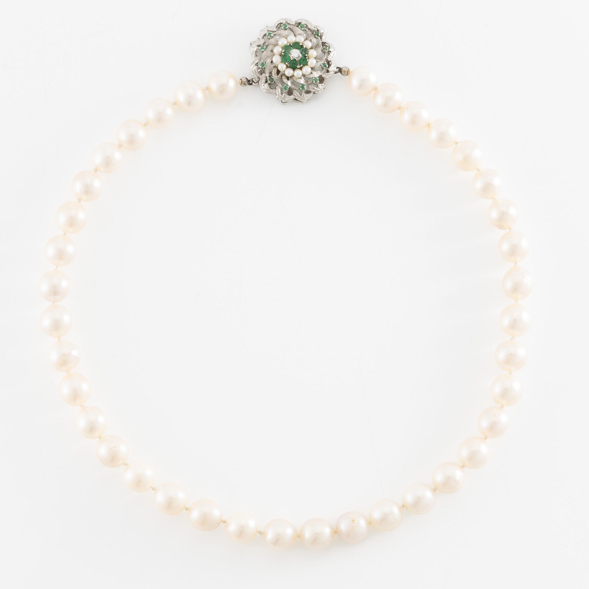 Pearl necklace, cultured pearls with a clasp in 18K white gold set with emeralds, diamonds, and pearls.