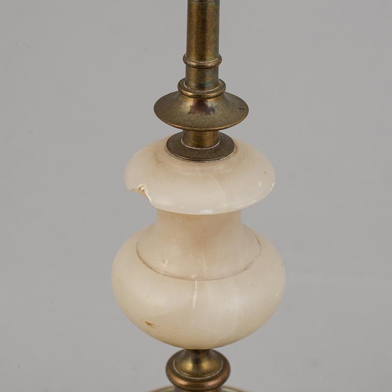 An alabaster mantle clock and pair of candlesticks, circa 1900.