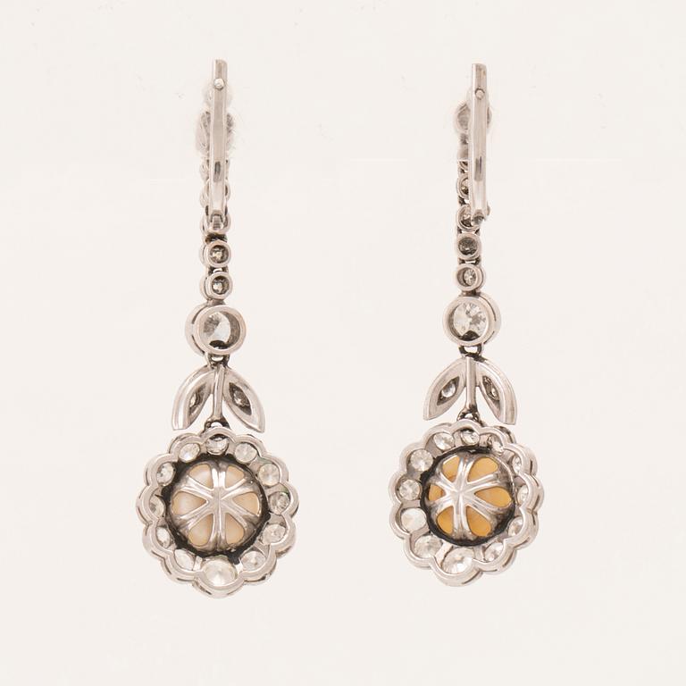 A pair of 18K white gold earrings set with cultured pearls and round brilliant-cut and old-cut diamonds.