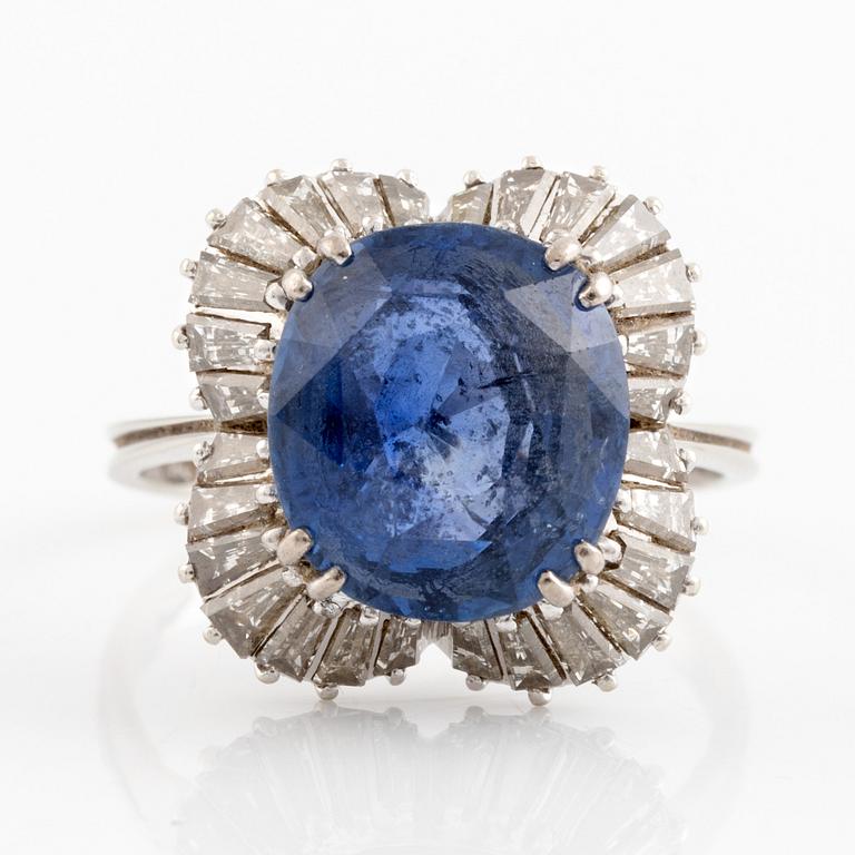 An 18K gold ring set with a faceted sapphire and tapered baguette-cut diamonds.