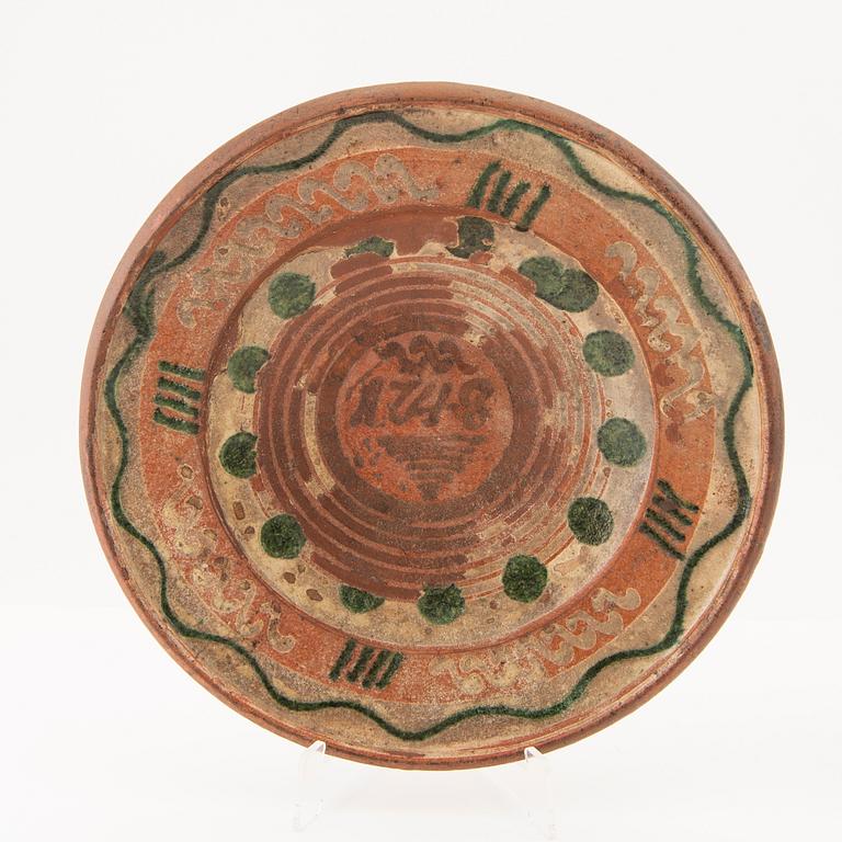 Two bowl plates ("Äggakagefat") 2 pieces from Skåne, one dated 1748 and 1891, engobed earthenware.