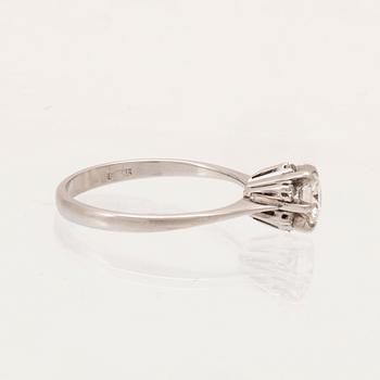 An 18K white gold ring set with a round brilliant cut diamond and single cut diamonds.