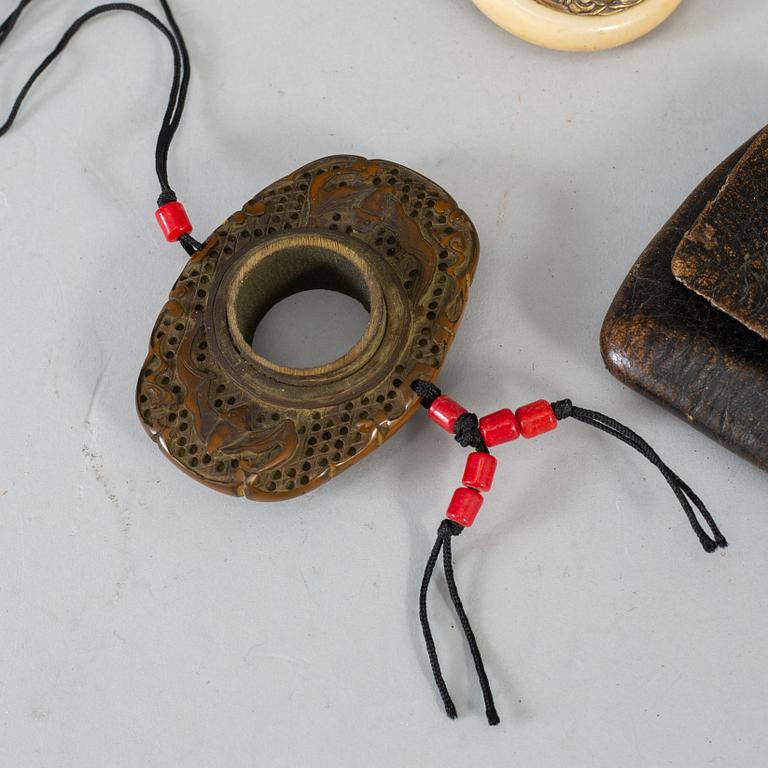 Two Japanese tobacco pouches, one with a pipecase and pipe, Meiji period (1868-1912), and a carved ornament.