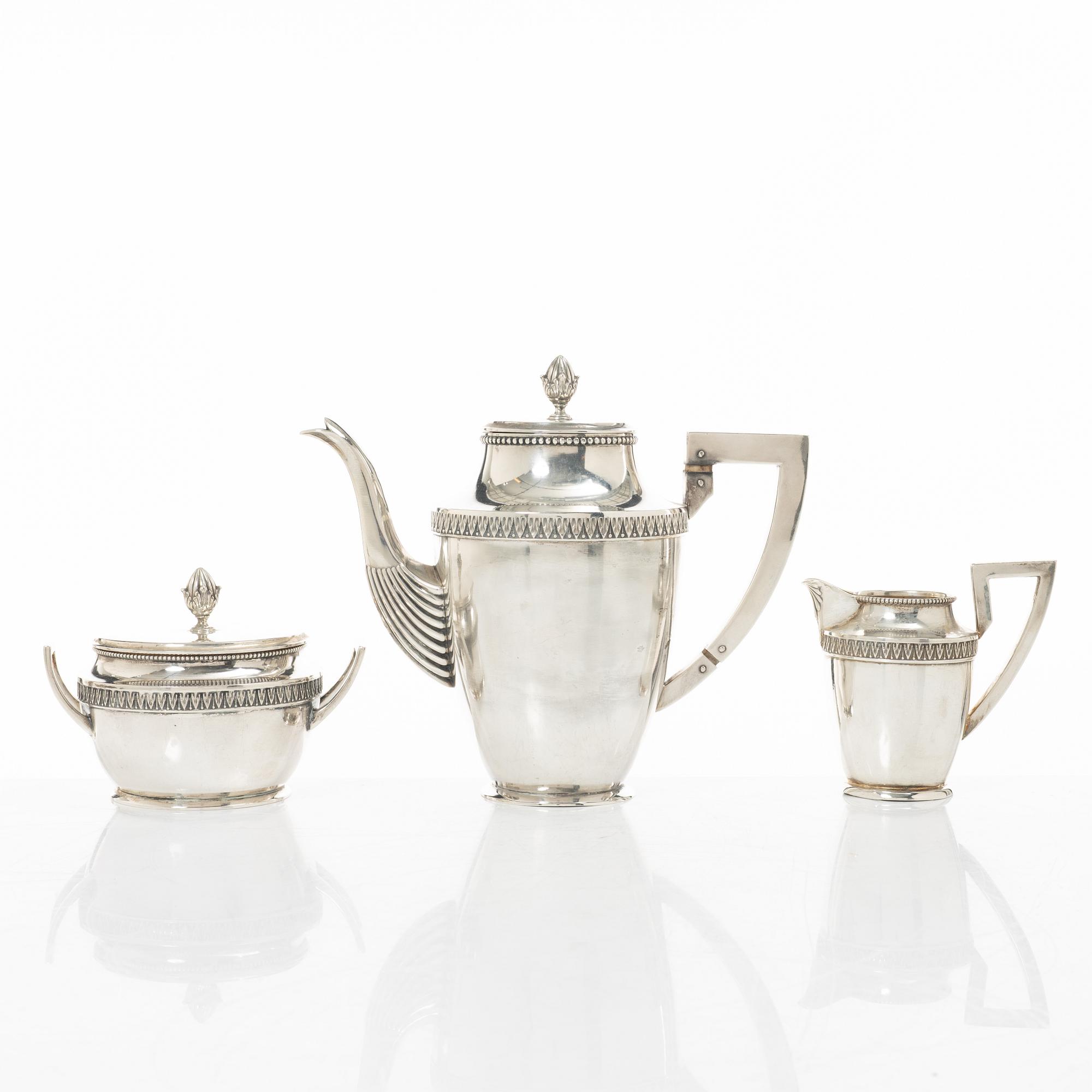 A silver coffee pot, creamer and sugar bowl, import marks of Axel Larson, Helsingborg 1920.