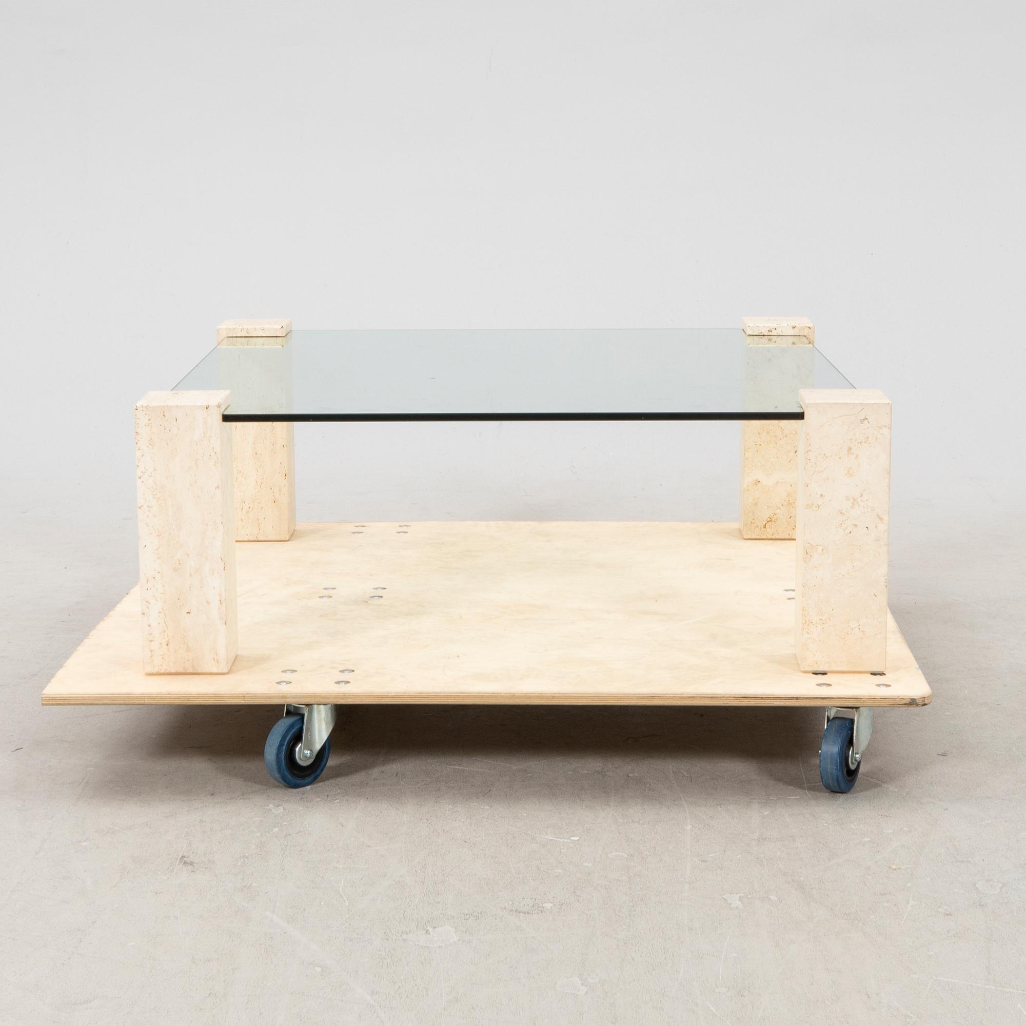 A late 20th century glass and travertin coffee table.