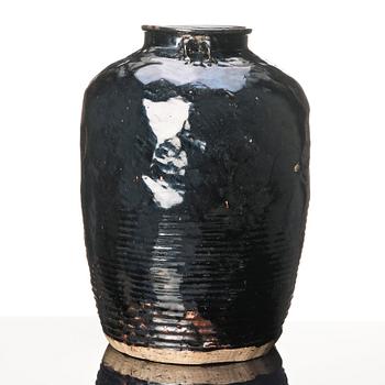 A large black glazed jar, presumably late Ming dynasty.
