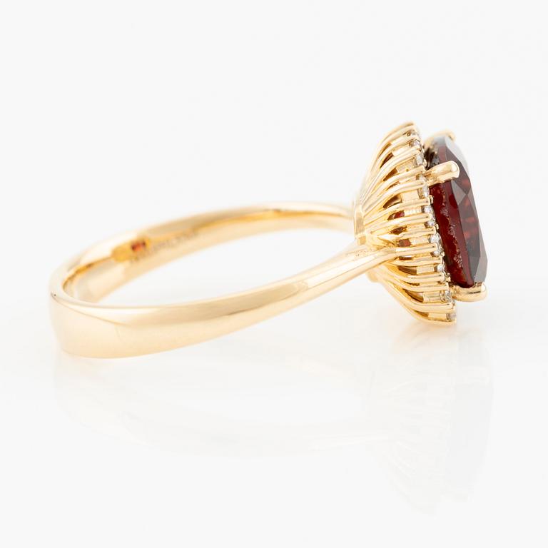 Ring in 18K gold with a faceted garnet and round brilliant-cut diamonds.