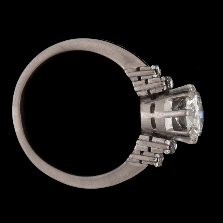 A ring with a brilliant-cut diamond flanked by baguette-cut diamonds. Total carat weights circa 1.80 cts.