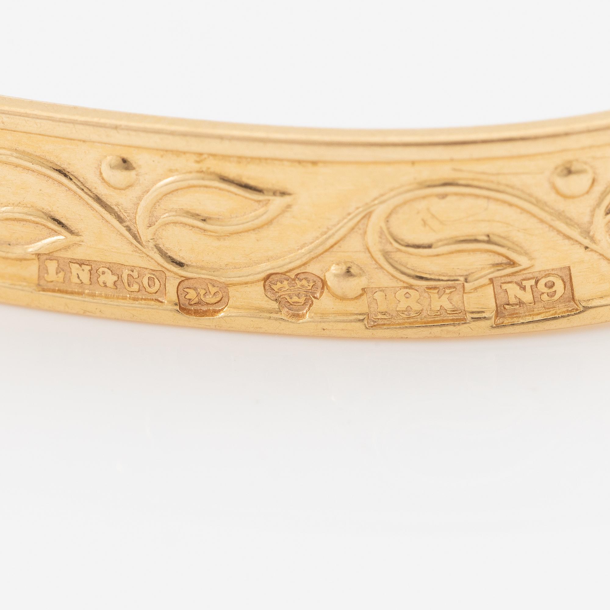 Arm ring, 18K gold with stylised decoration.