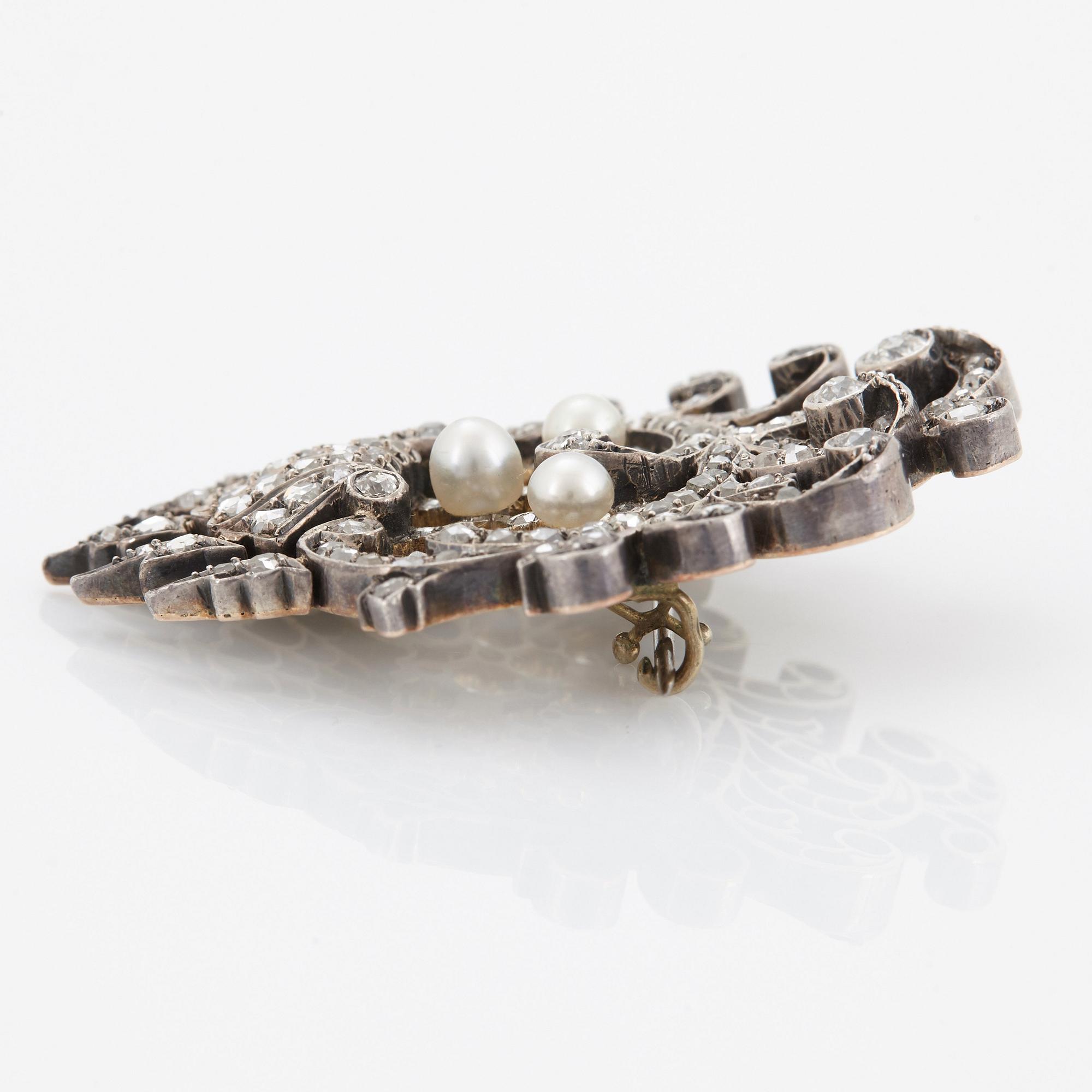 An 18K gold and silver brooch set with old- and rose-cut diamonds.