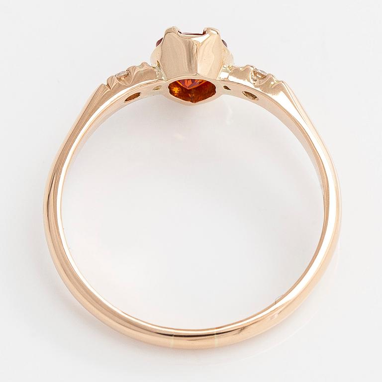 A 14K gold ring, with a pear-cut orange sapphire and diamonds.