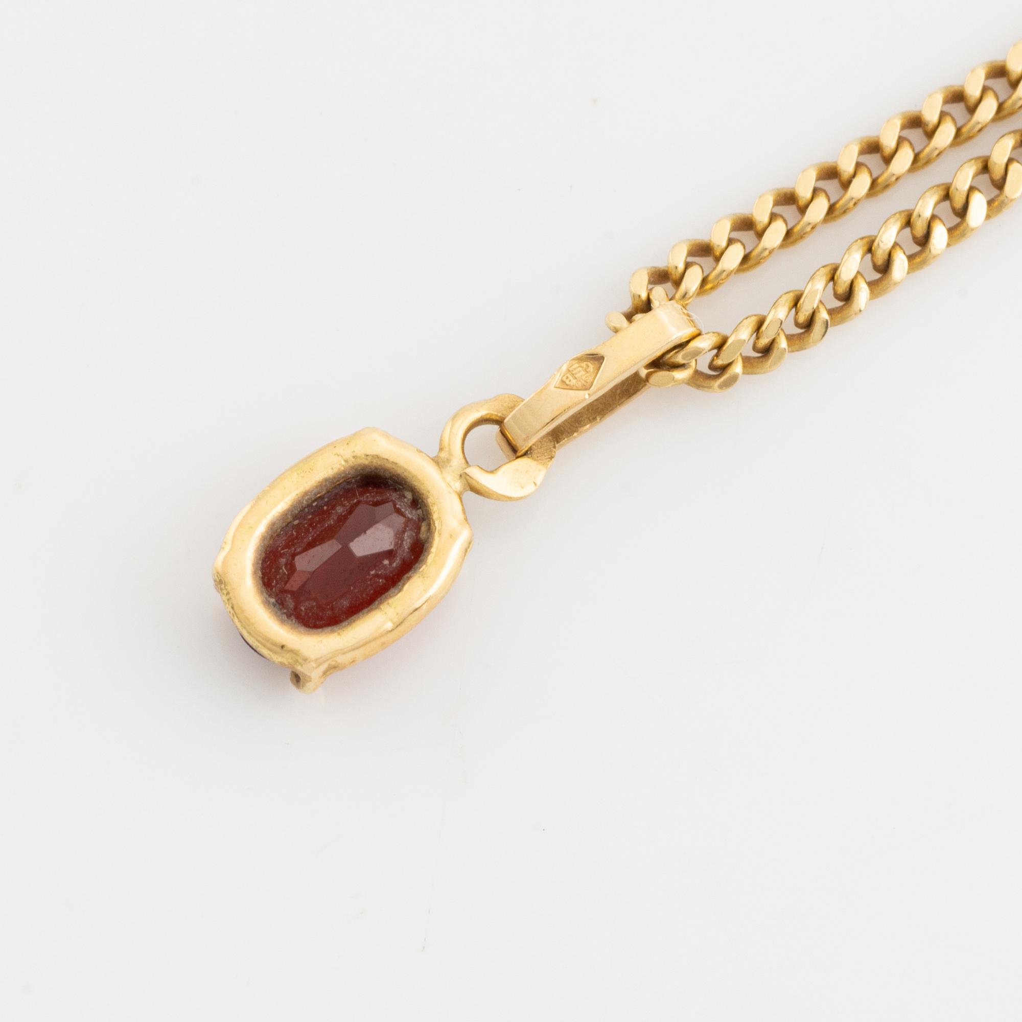 Pendant with chain with red stone, possibly garnet.