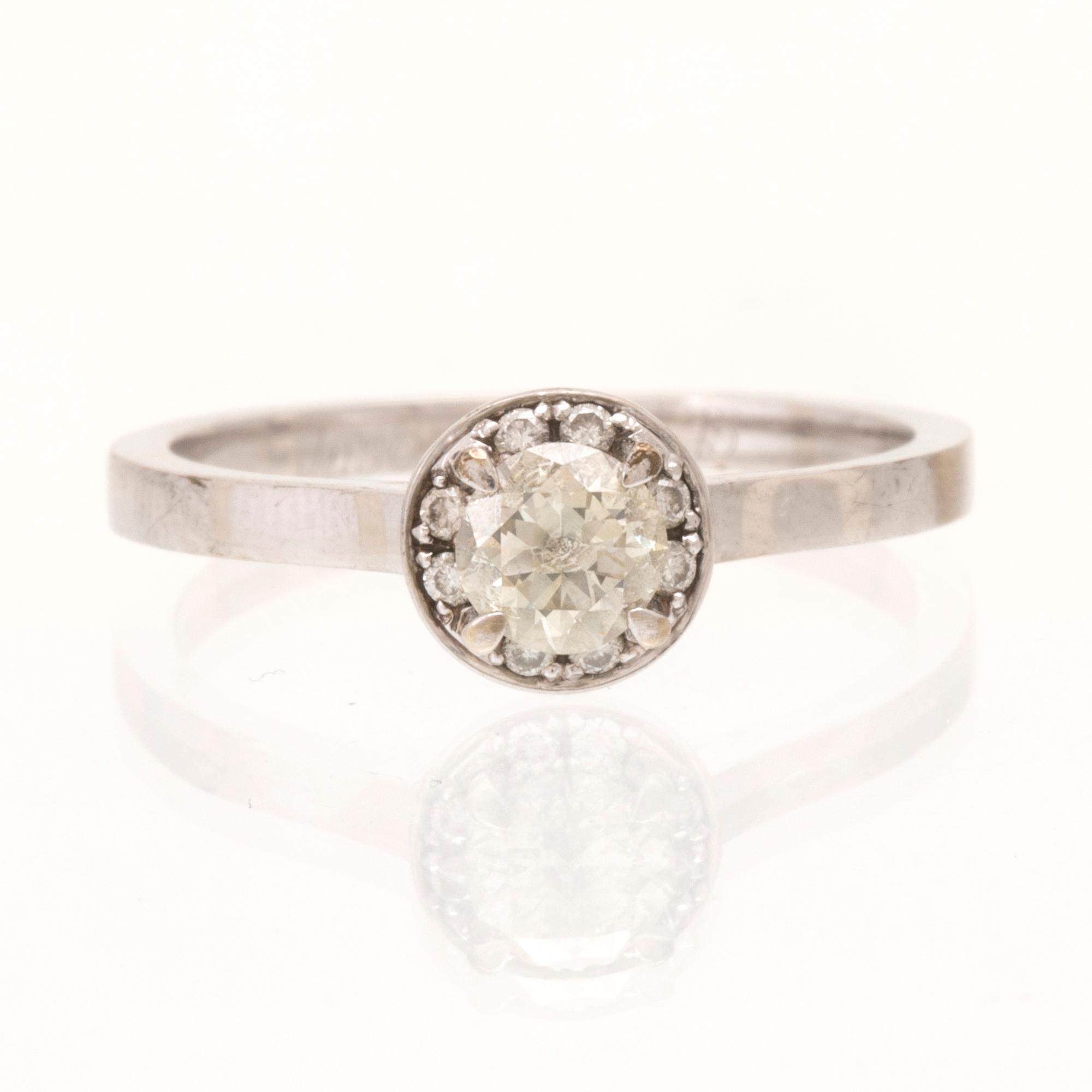 An 18K white gold ring set with round brilliant-cut diamonds.