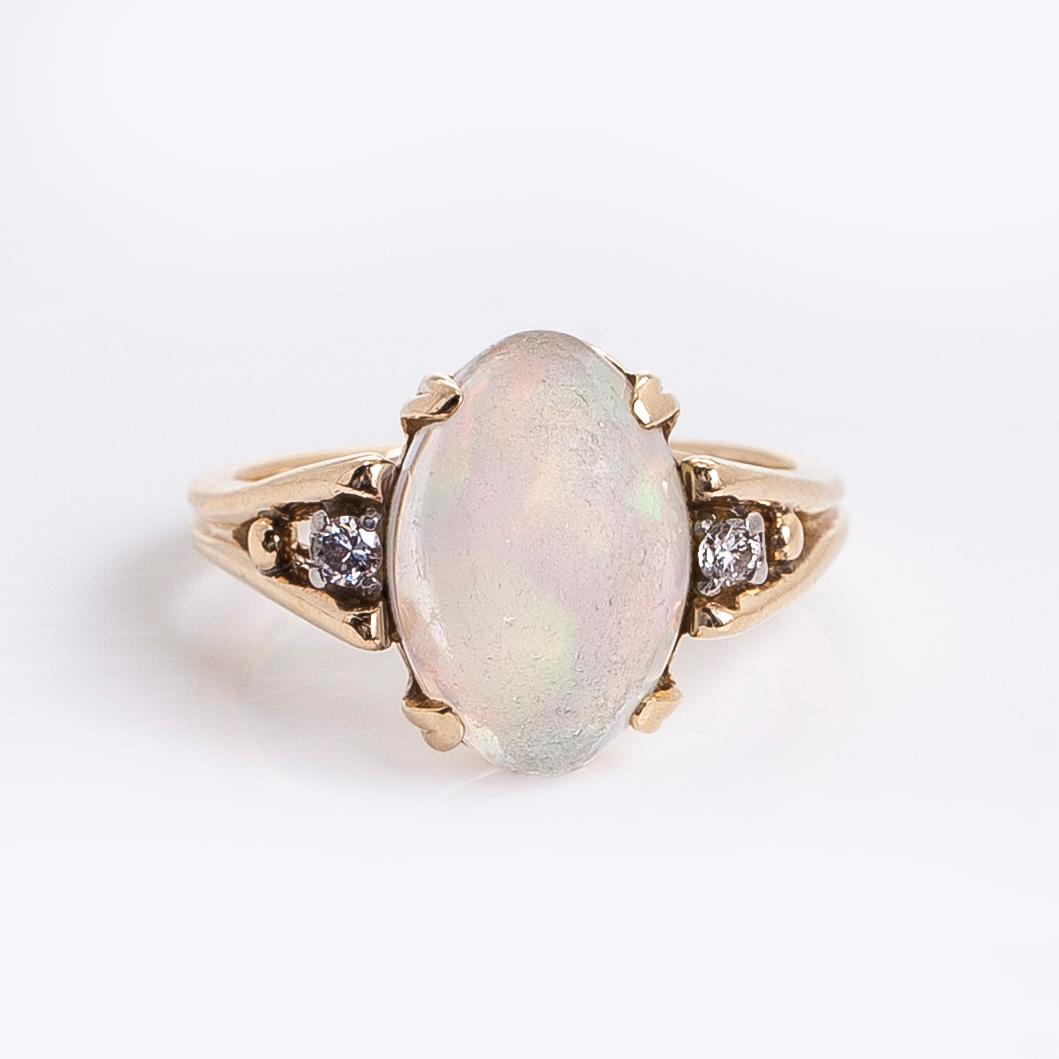 Ring in 14K gold with an oval opal and diamonds.