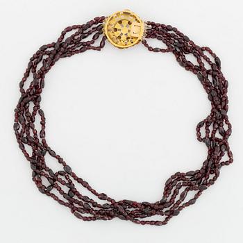 A five strand garnet necklace with a 14K gold clasp set with garnets.