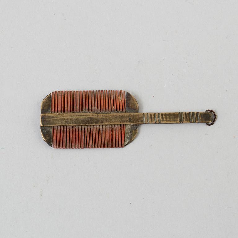 A 18th century brass comb.