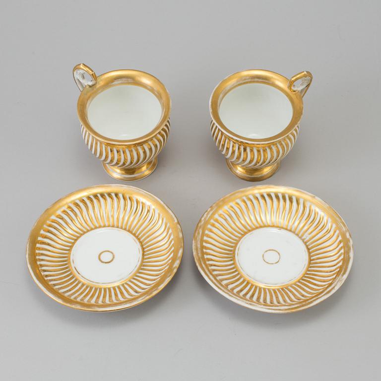 a pair of late empire porcelain cups with saucers from the first half of the 19th century.