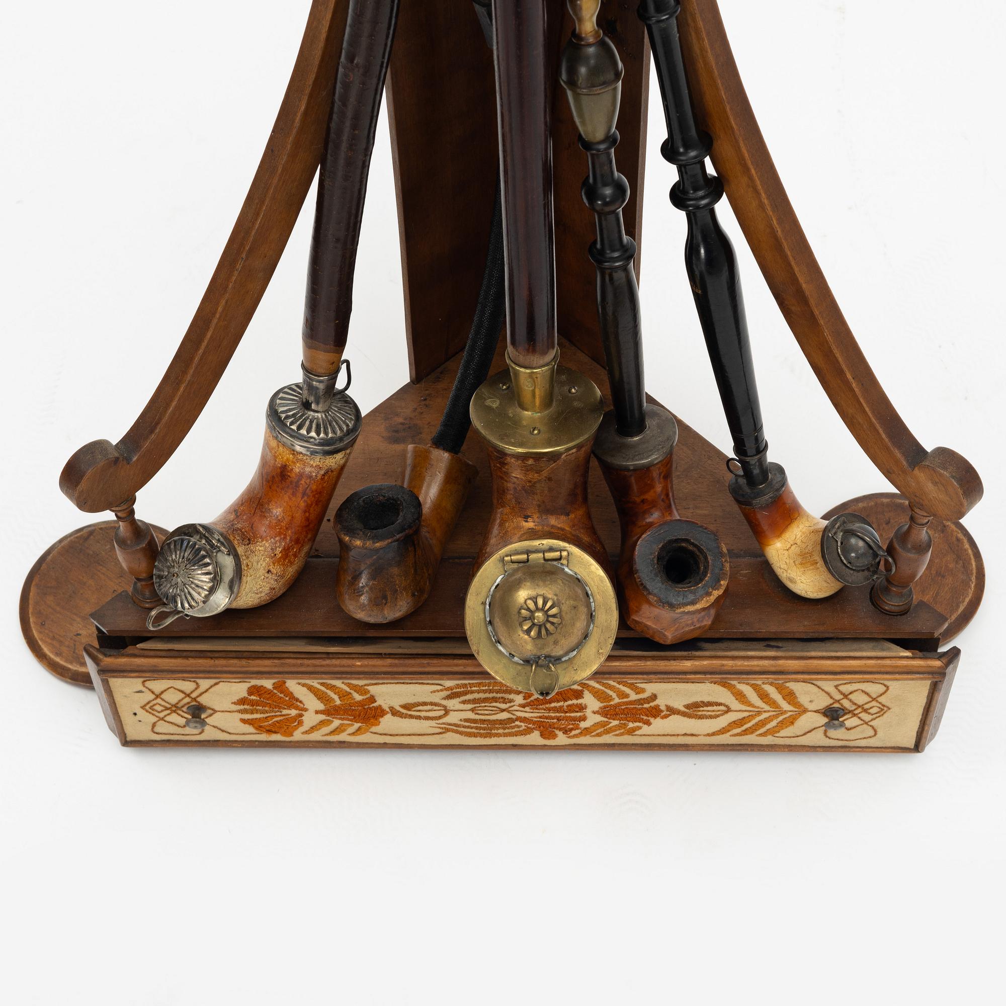 A pipestand and four pipes, circa 1900.