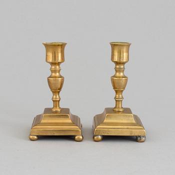 A pair of brass candlesticks, 18th Century.