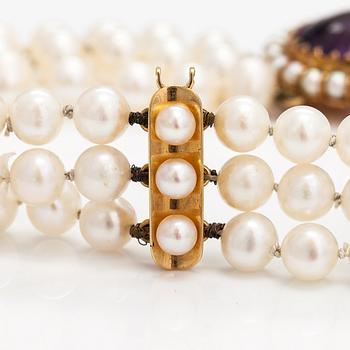 A three-strand cultured pearl collier with an amethyst and 14K gold.