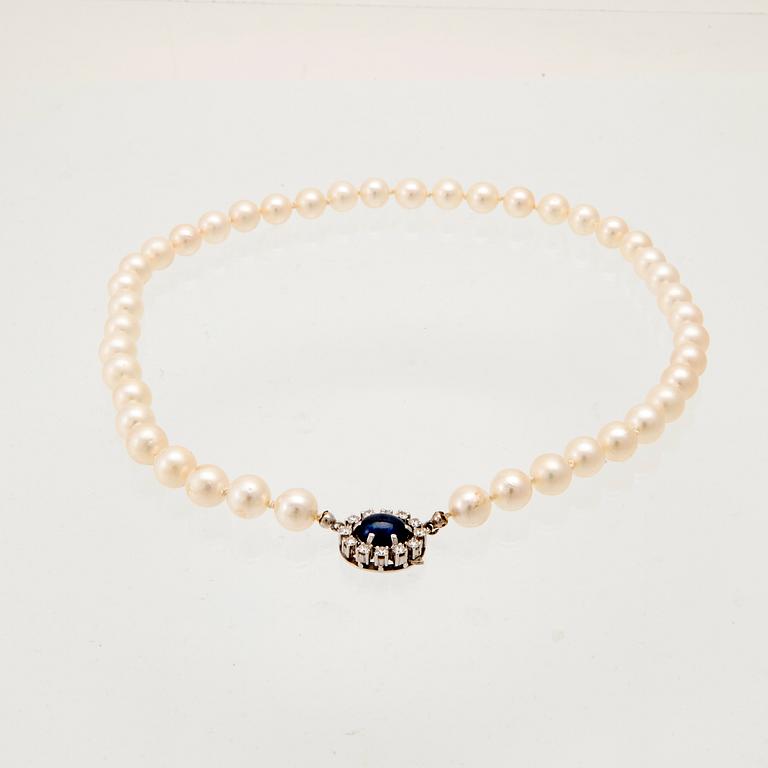 Necklace with cultured pearls, clasp in 18K white gold with cabochon-cut sapphire and round brilliant-cut diamonds.