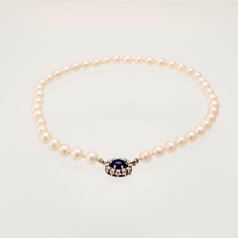 Necklace with cultured pearls, clasp in 18K white gold with cabochon-cut sapphire and round brilliant-cut diamonds.