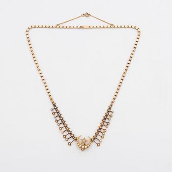 A gold necklace set with pearls.