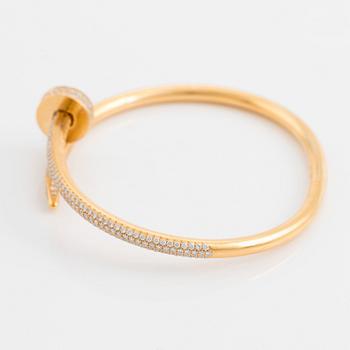 A Cartier "Juste un Clou" bracelet in 18K gold set with round brilliant-cut diamonds.