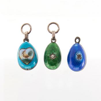 Three pendants of silver and enamel, in the shape of eggs.