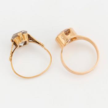Two 18K gold rings set with synthetic, white spinels.